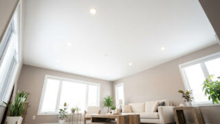Salon moderne avec un plafond blanc lisse, des spots encastrés et des murs aux tons neutres.