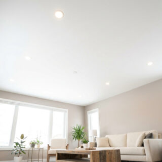 Salon moderne avec un plafond blanc lisse, des spots encastrés et des murs aux tons neutres.