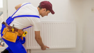 Technicien installant un radiateur mural blanc