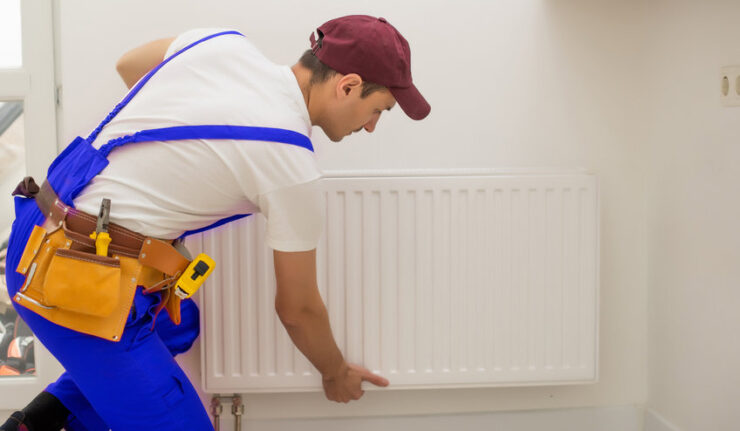 Technicien installant un radiateur mural blanc